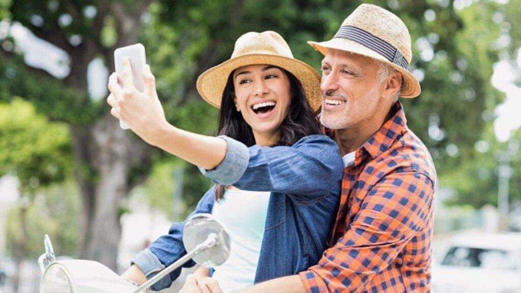 young woman taking selfie with older man